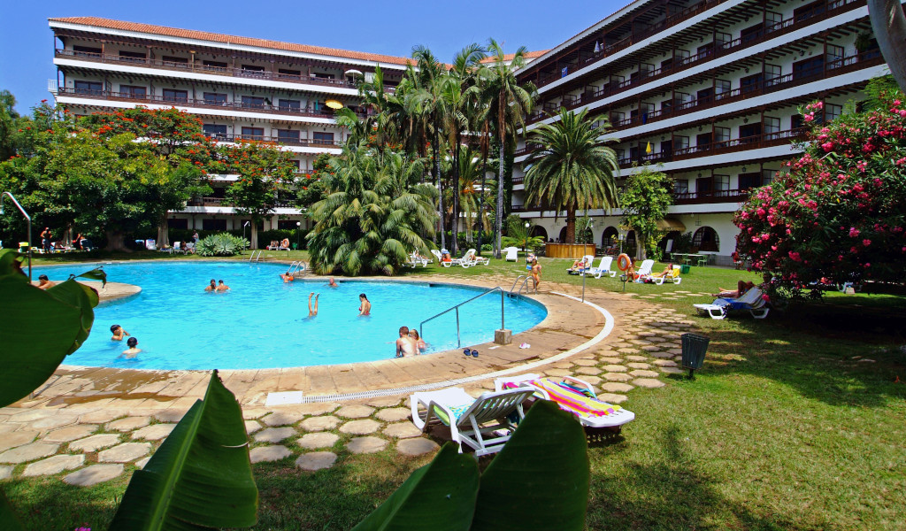 Outdoor swimming pool at a Tenerife hotel with people swimming and lounging.