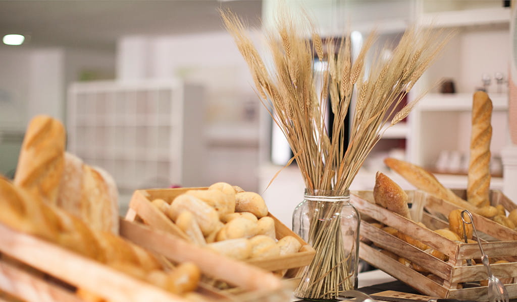 Breads and wheat stalks displayed in baskets and jars at bakery in Tenerife.