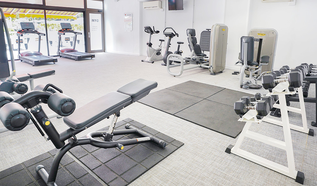 Gym equipment including treadmills and weights in a Tenerife fitness center.