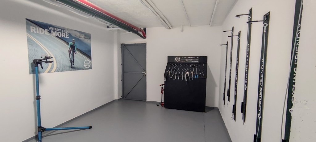 Bicycle repair room with tools and poster reading Worry Less, Ride More in Tenerife.