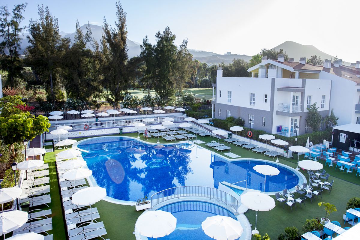 Outdoor swimming pool with loungers and umbrellas at a hotel in Tenerife.