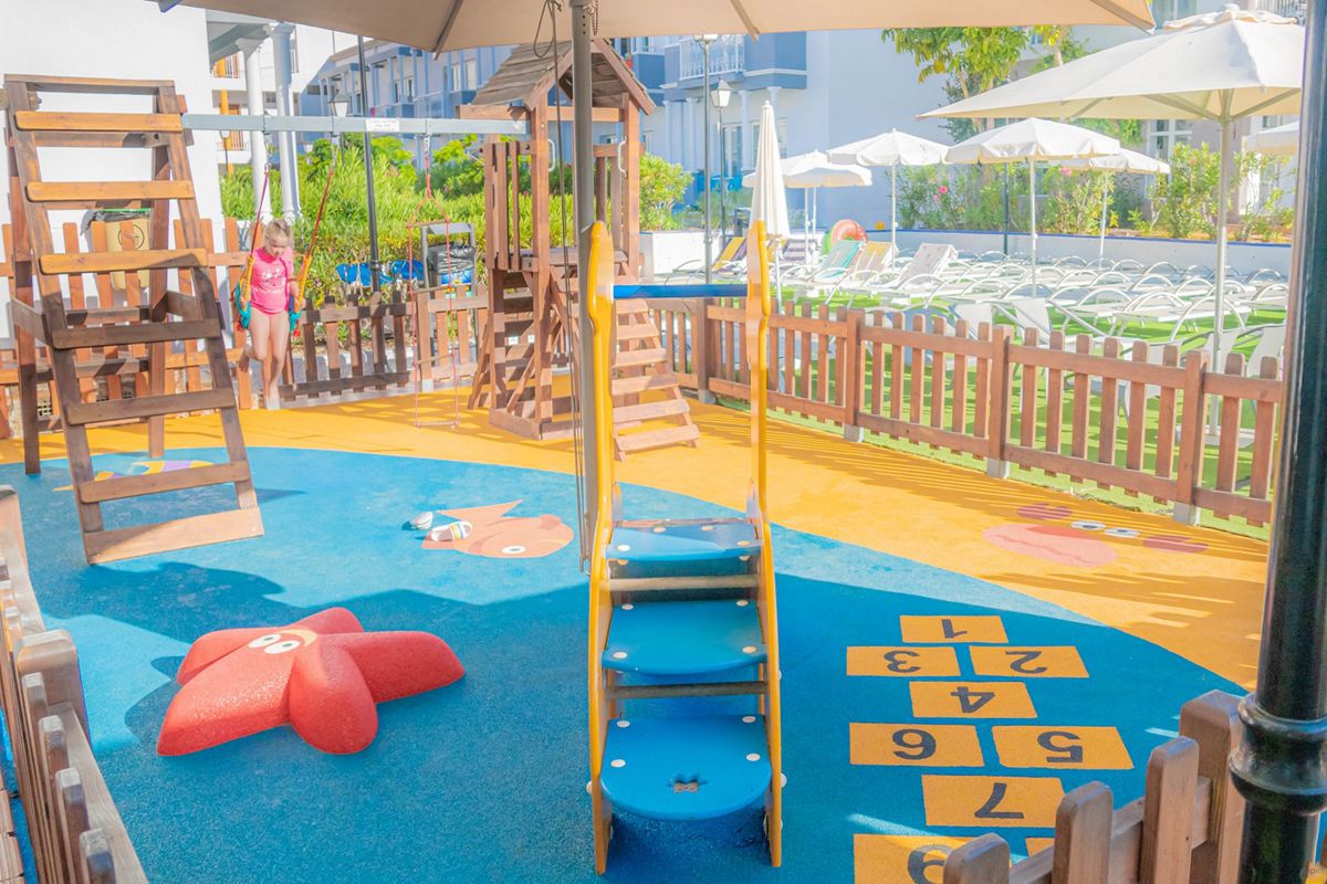 Child playing in a colorful playground with climbing structures in Tenerife.