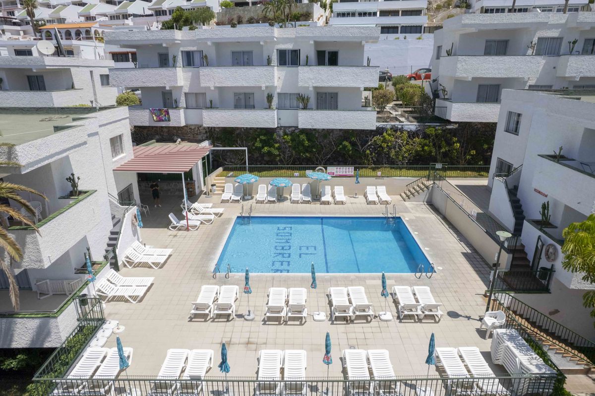 Outdoor pool area with lounge chairs and tables at El Sombrero, Los Gigantes, Tenerife.