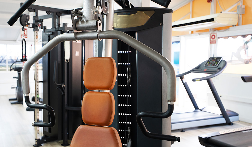Gym equipment including a chest press machine and treadmill in Tenerife.