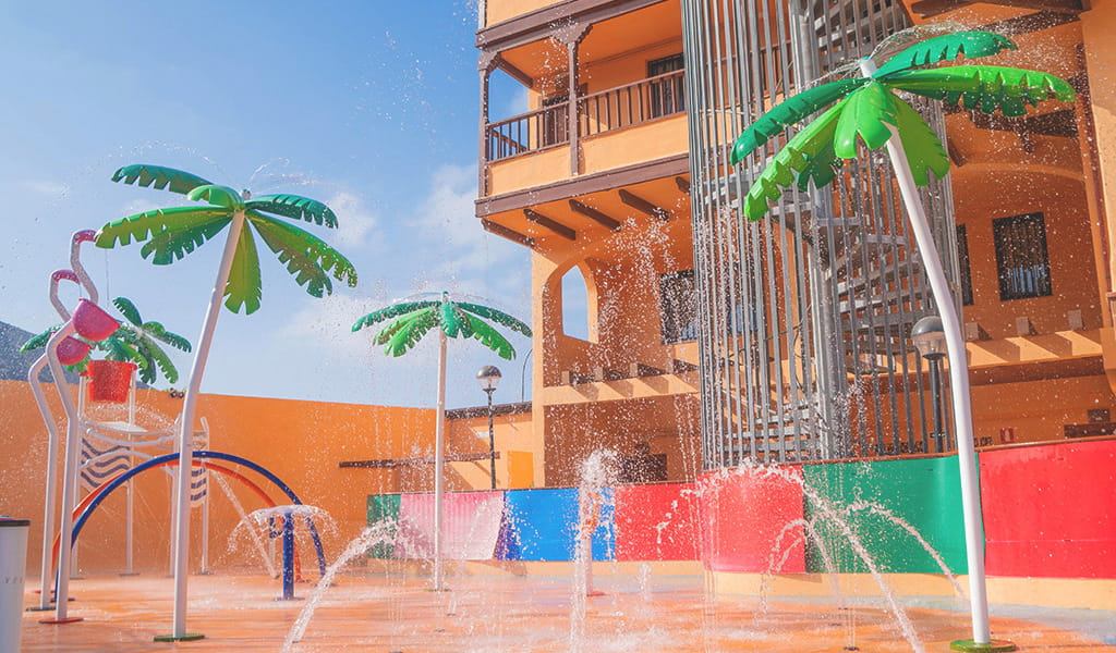 Children's water play area with palm tree fountains in Tenerife.