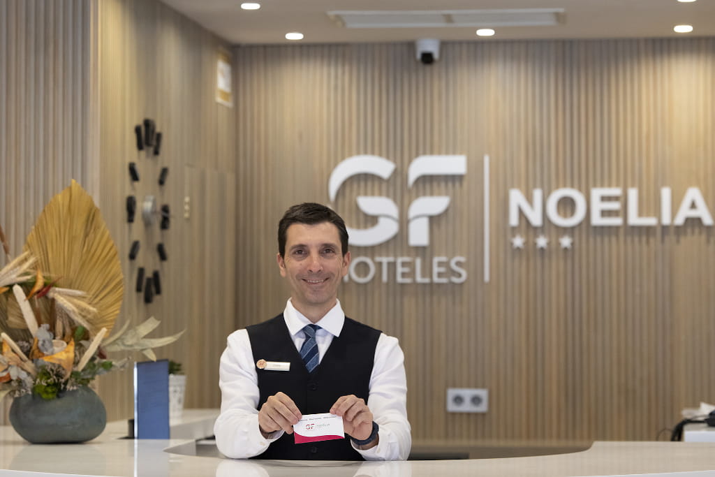 Receptionist holding card at Noelia Hotel in Tenerife.