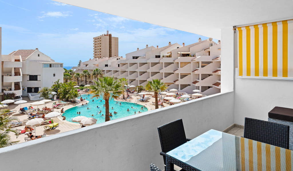 View of hotel pool area with parasols and lounge chairs in Tenerife.