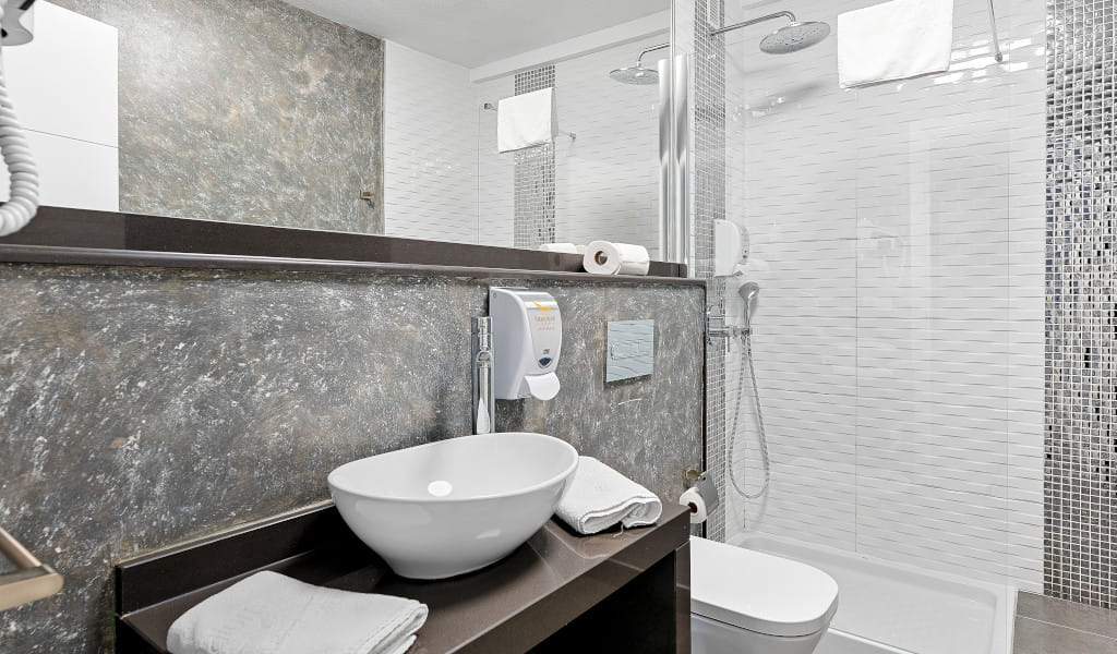 Modern bathroom with sink, towels, and shower in a Santa Cruz de Tenerife hotel.