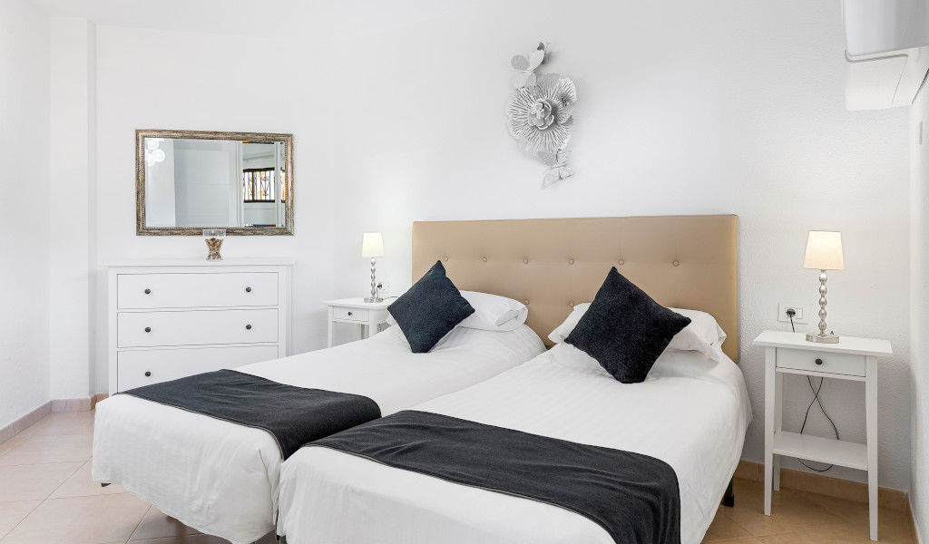 Two beds with black cushions in a bright room in Tenerife.