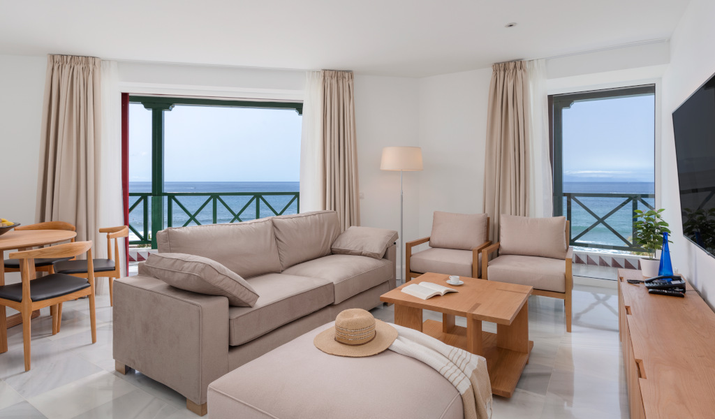 Living room with ocean view in Tenerife, featuring sofa and chairs.