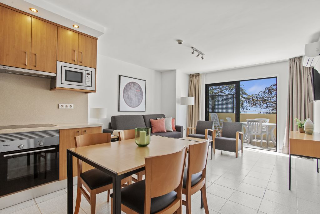 Modern living area in Tenerife apartment with kitchen and balcony.