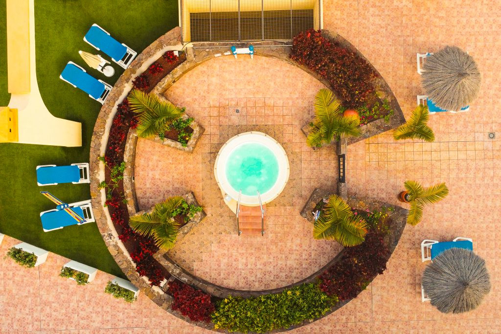 Aerial view of circular jacuzzi with loungers in Tenerife resort.
