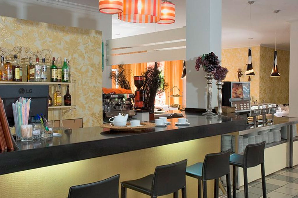 Bar area with stools, liquor bottles, teapot, and decorative lighting in Tenerife.