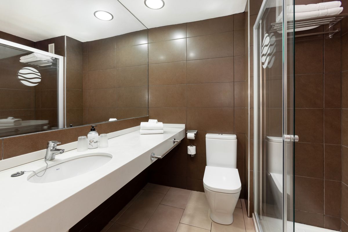 Modern bathroom with glass shower, toilet, and sink in Tenerife.