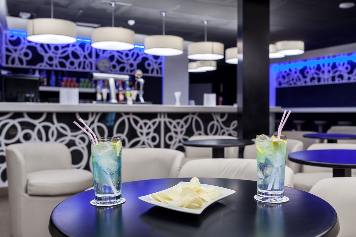 Two cocktails with lemon and straws on a table, near a bar in Tenerife.