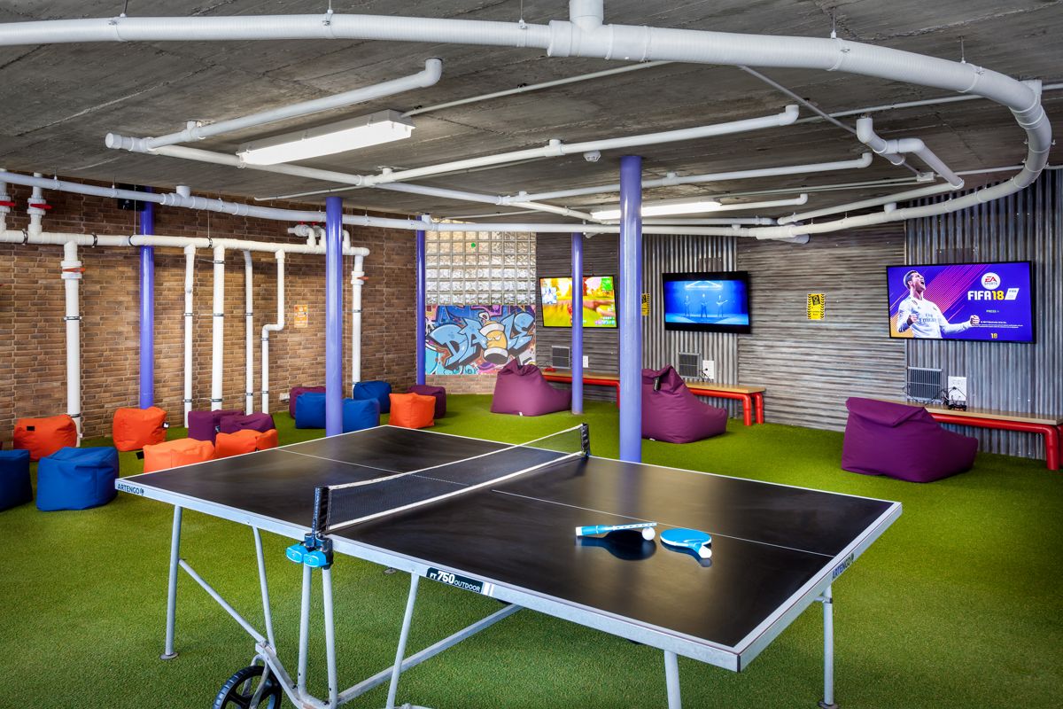 Table tennis and bean bags in leisure room, Tenerife. TVs display FIFA 18 and other games.