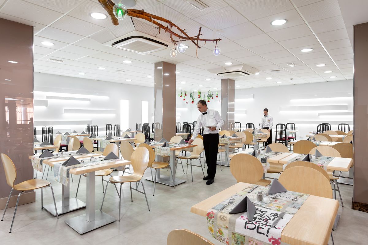 Restaurant with tables set, waiters serving, location in Tenerife.