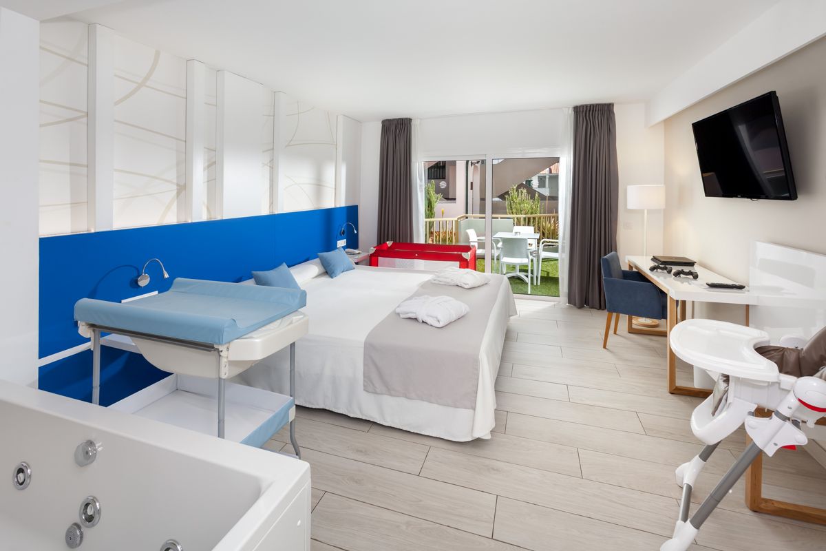 Family-friendly hotel room with bed, baby changing station, and terrace in Tenerife.