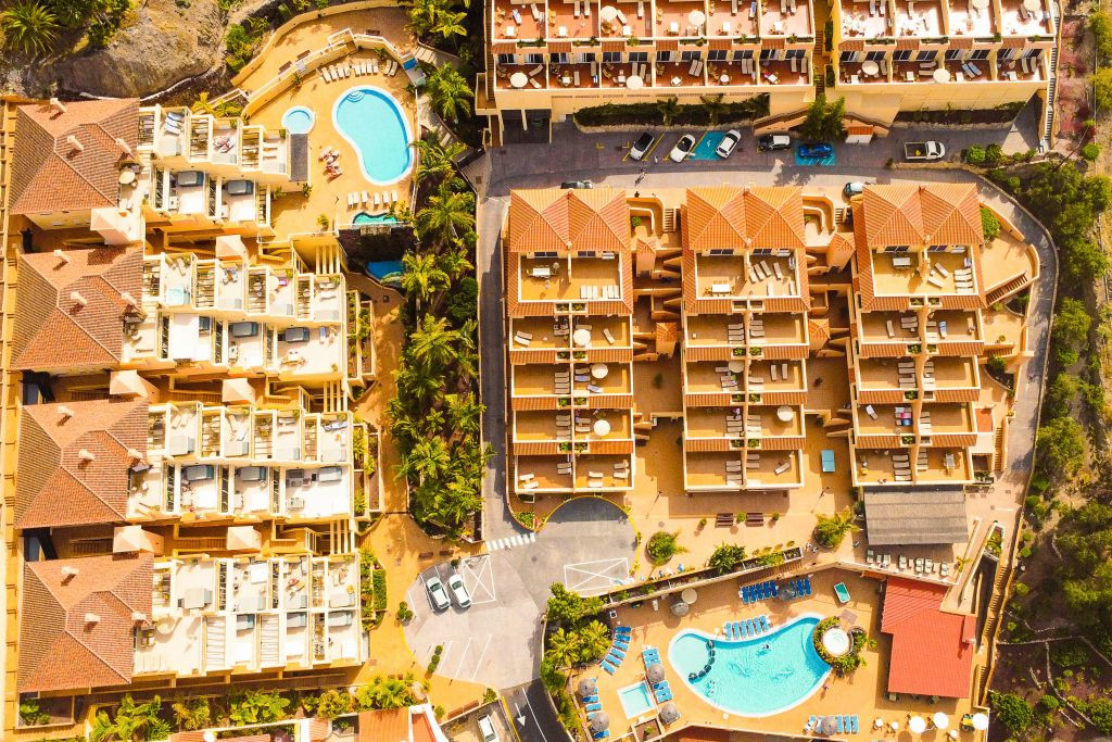 Aerial view of apartment complex with two pools in Tenerife.