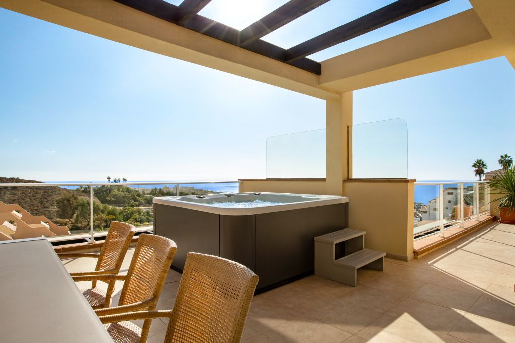 Terrace with a jacuzzi, chairs, and ocean view in Tenerife.