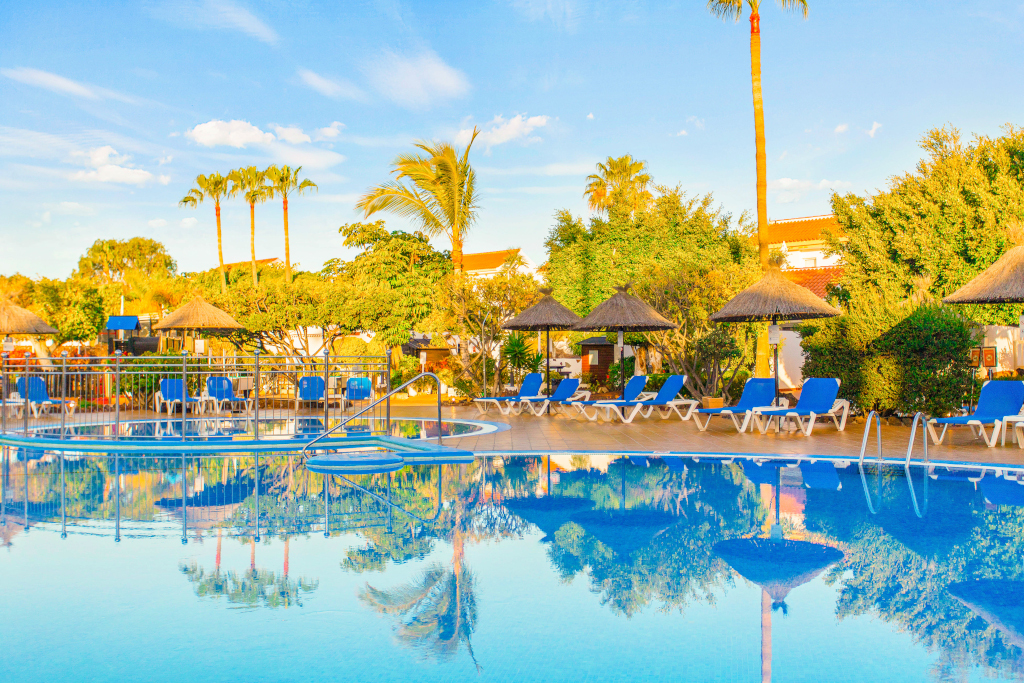 Outdoor swimming pool with sun loungers and umbrellas in Tenerife.