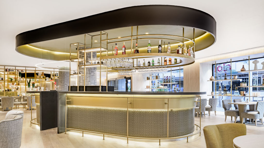Modern bar with a suspended shelf and seating area in Tenerife.
