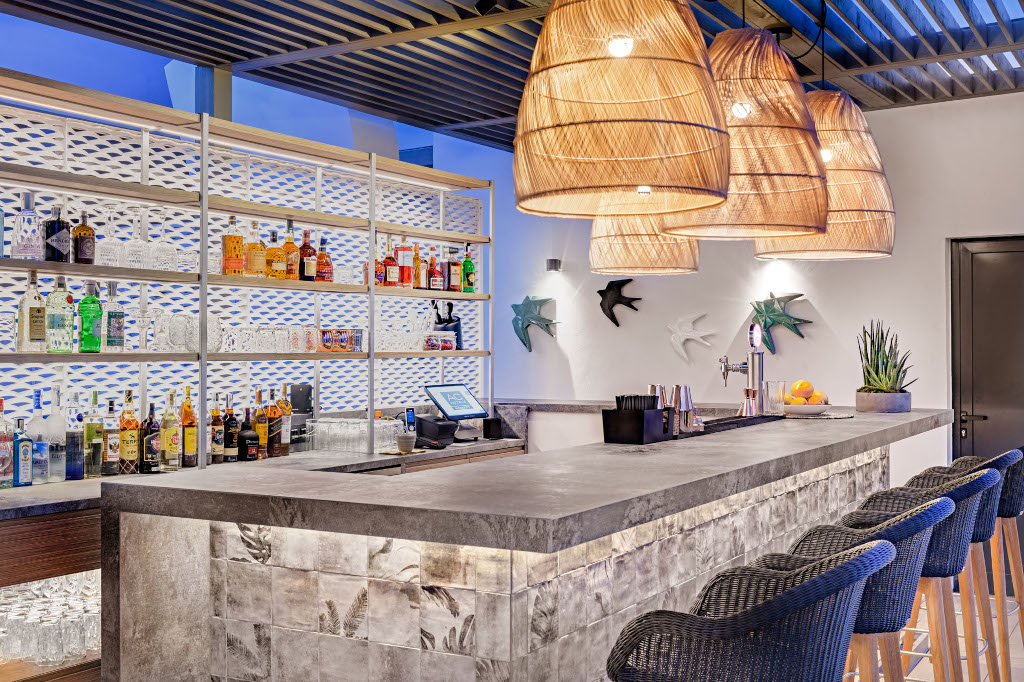 Bar counter with drinks, decorative lamps, and wall art in a Tenerife location.