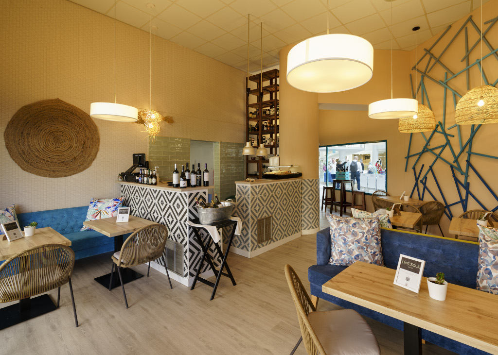 Cozy cafe interior in Tenerife with wooden tables, chairs, and blue accents.
