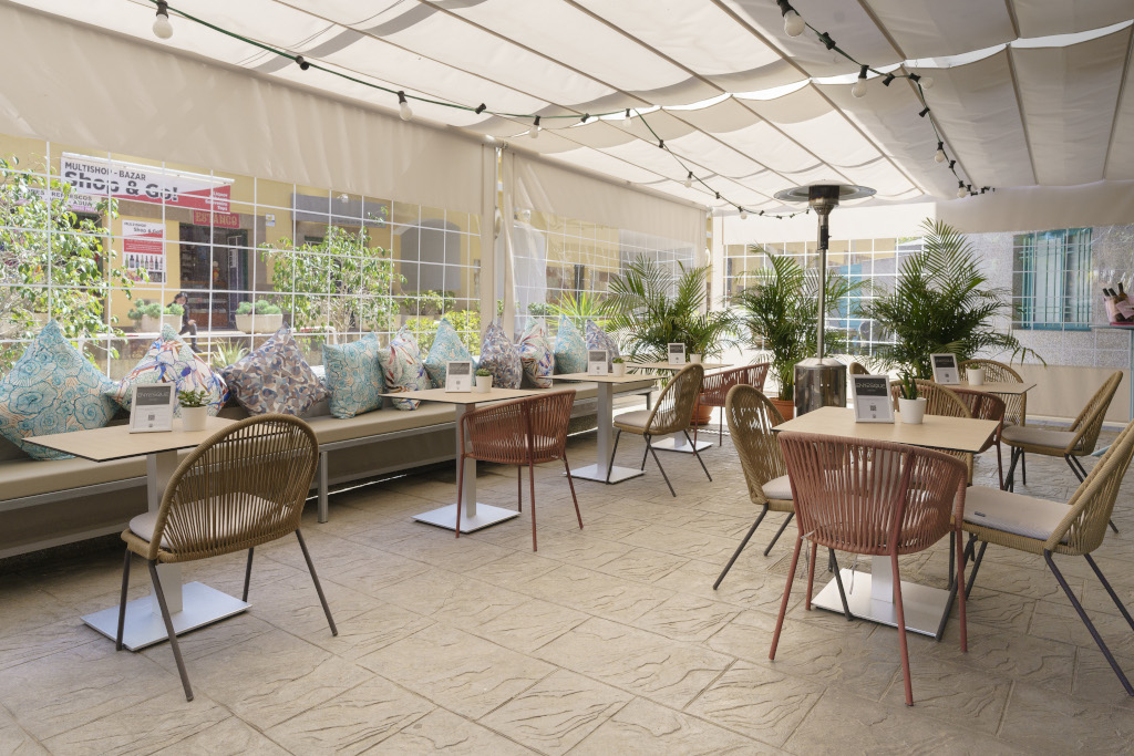 Outdoor café seating with colorful cushions and plants in Tenerife.
