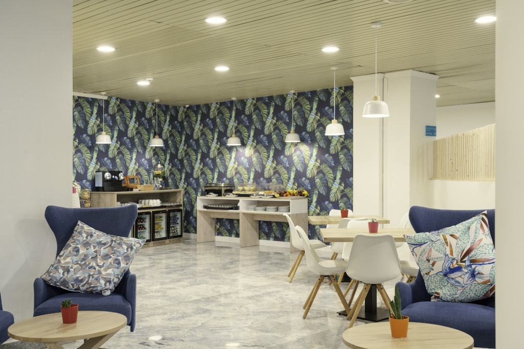Lounge area with chairs, tables, and a buffet setup in a Tenerife hotel.