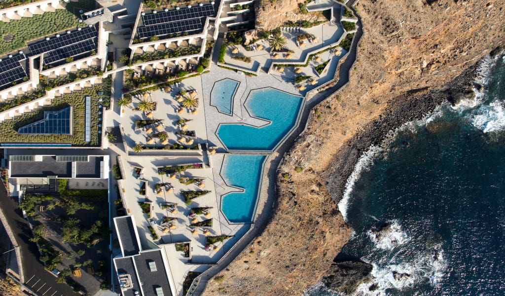 Resort with geometric pool near rocky shoreline in Tenerife.