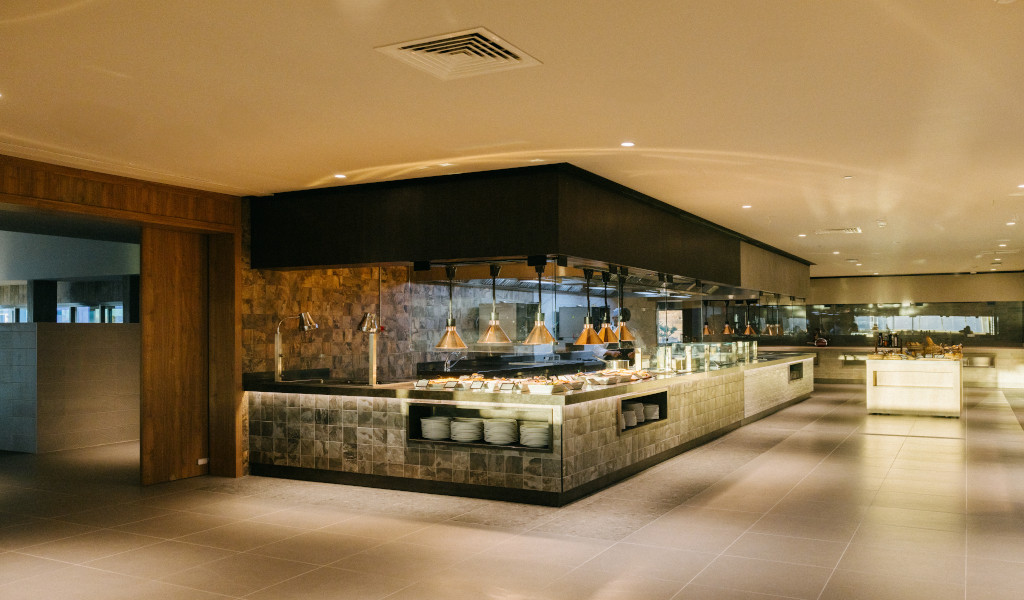 Buffet setup in a modern Tenerife restaurant with various dishes and dim lighting.