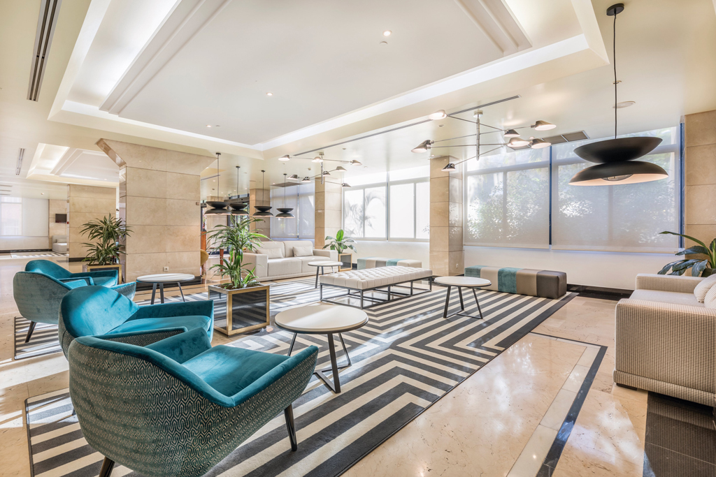 Modern hotel lobby with seating area and geometric rug in Tenerife.