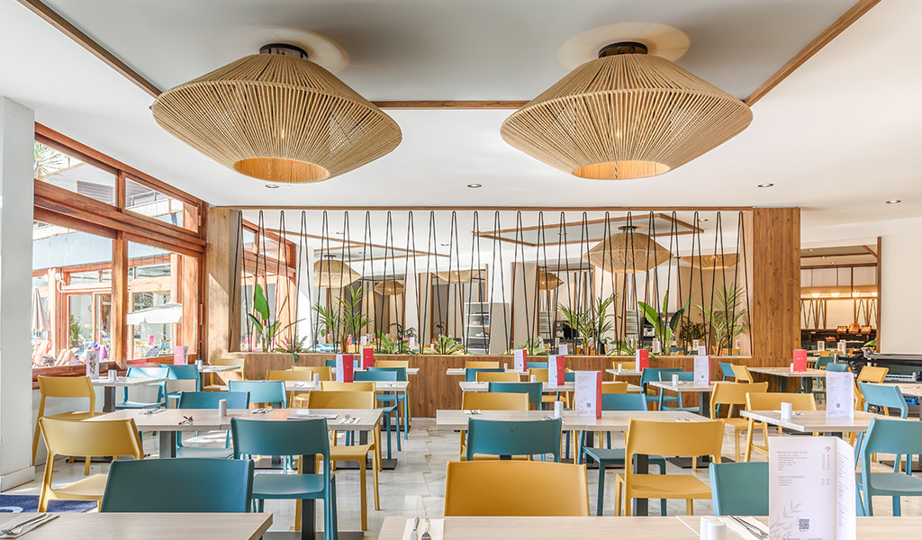 Dining area with blue and yellow chairs at a restaurant in Tenerife.