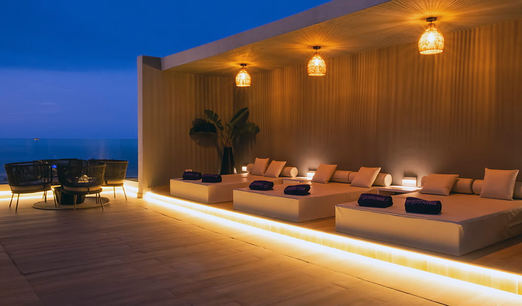 Rooftop lounge with seating and lit cabanas in Tenerife hotel.
