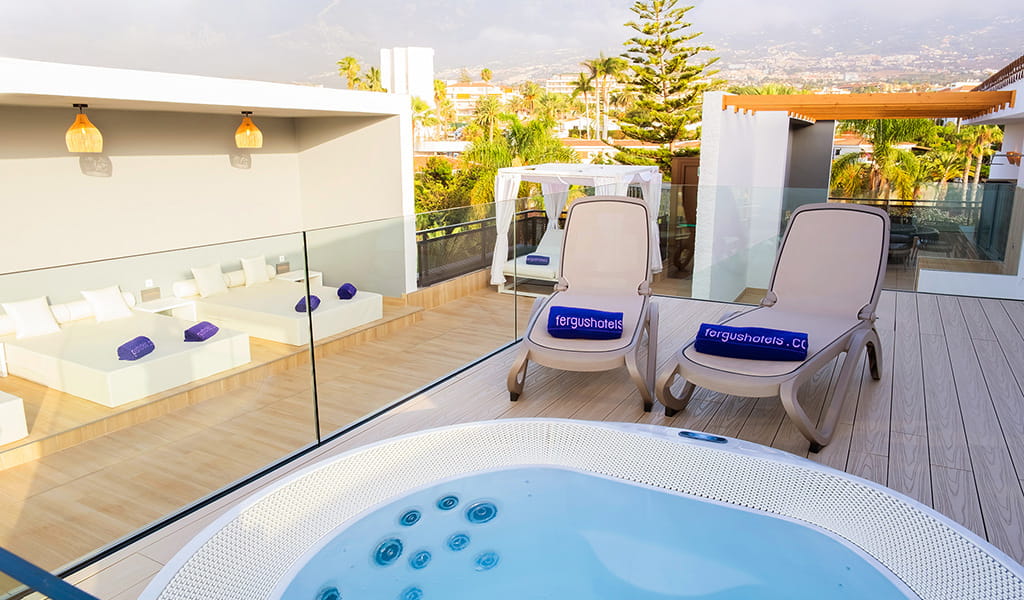 Rooftop terrace in Tenerife with jacuzzi, sun loungers, and cabana.