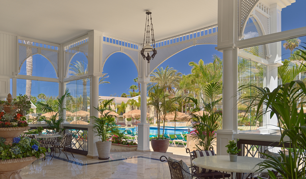 Luxury hotel interior with view of pool and palm trees in Tenerife.