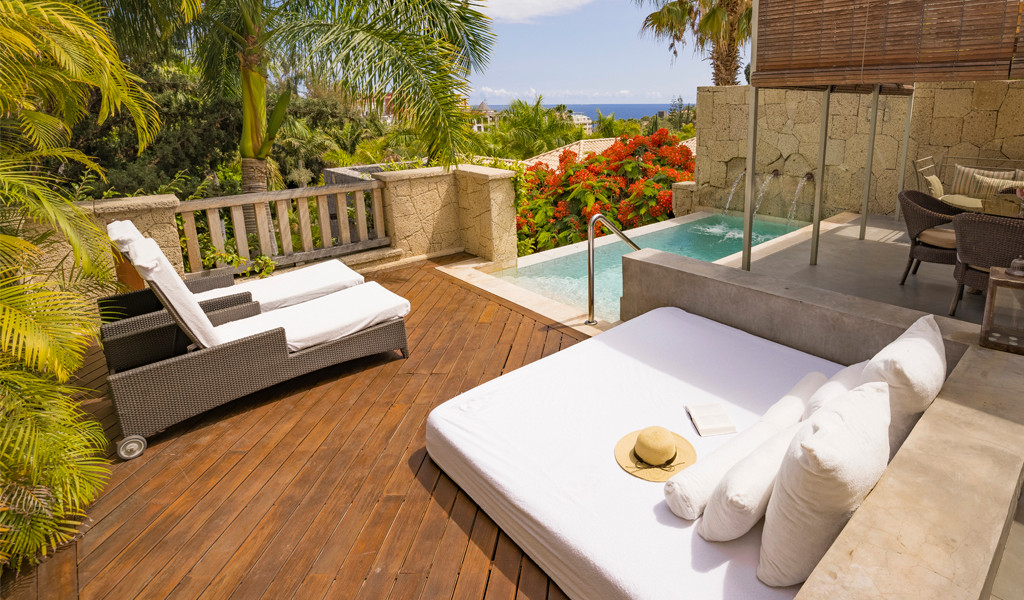 Sun loungers and private terrace with pool overlooking gardens in Tenerife.