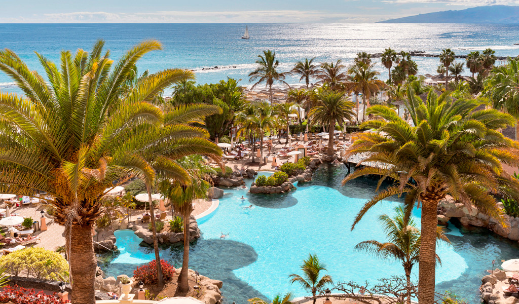 Pool and palm trees overlooking the ocean in Tenerife.