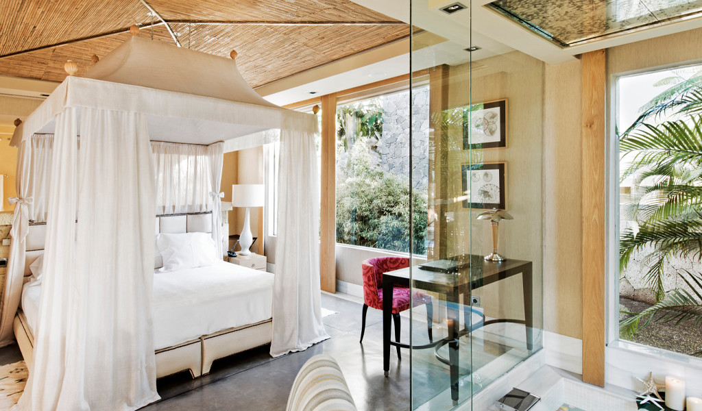 Luxurious hotel room with canopy bed and desk in Tenerife.