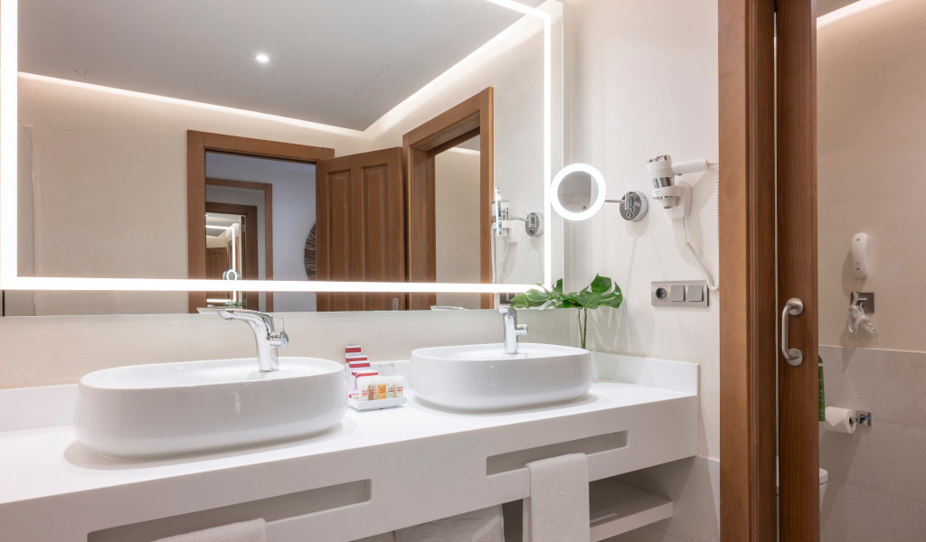 Modern bathroom with double sinks and illuminated mirror in Tenerife hotel.