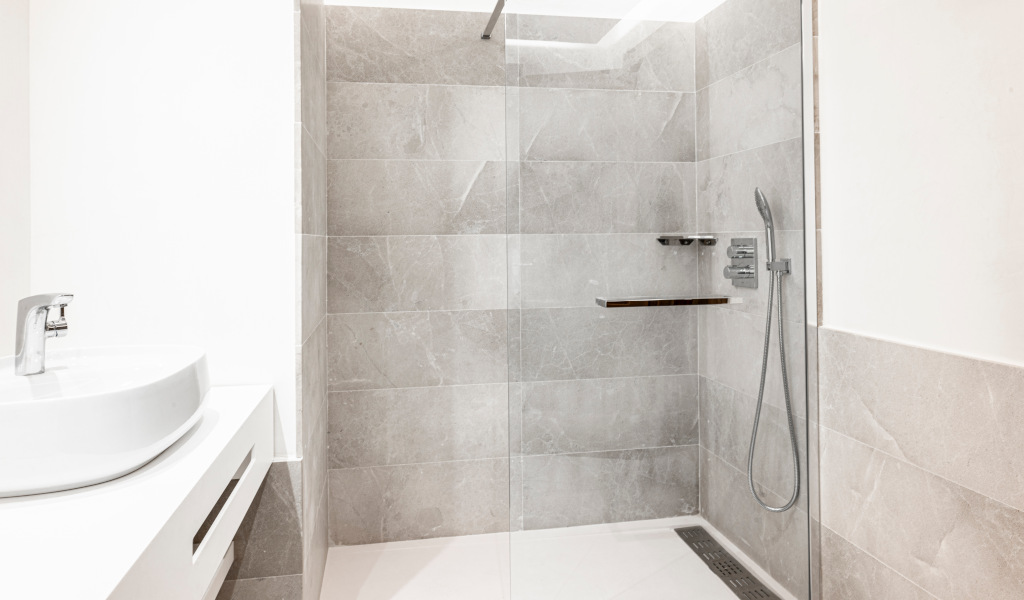 Modern shower and sink with grey tiles in a bathroom in Tenerife.
