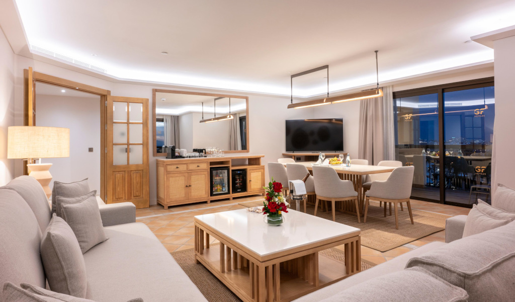 Spacious living room with dining area and large window at GF Victoria, Tenerife.
