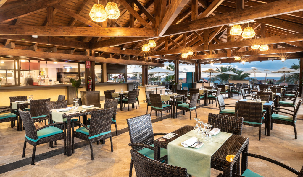 Outdoor restaurant with wooden ceiling and set tables in Tenerife.