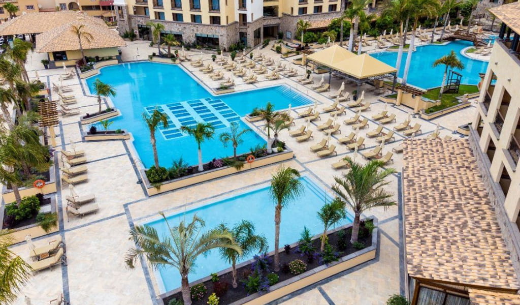 Aerial view of hotel pools and lounge chairs in Tenerife.