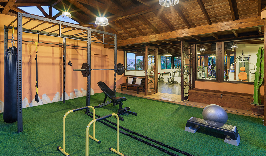 Gym with fitness equipment and exercise areas at a Tenerife location.