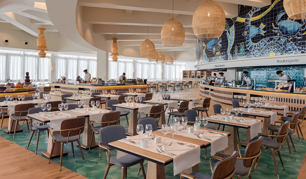 Dining area in a Tenerife restaurant with set tables and a mosaic wall.