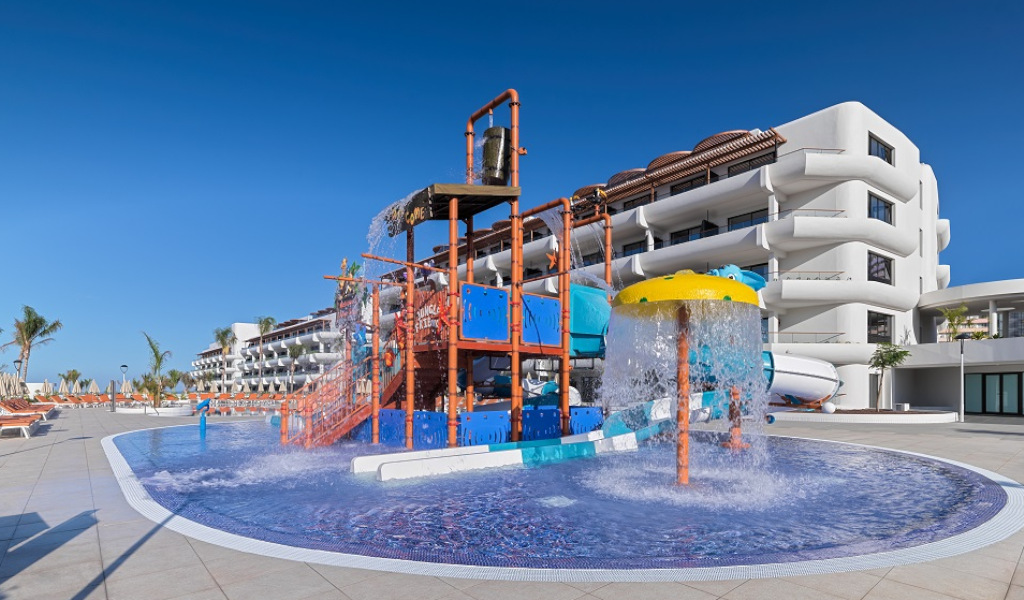 Children's water park area at a hotel in Tenerife with slides and splash zones.