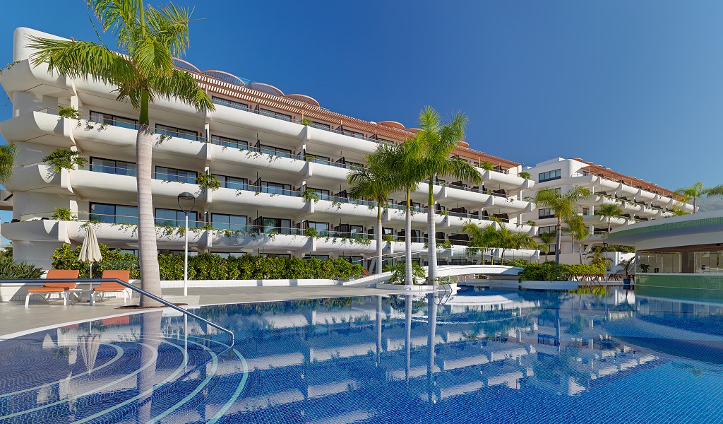 Modern hotel with pool and palm trees in Tenerife.