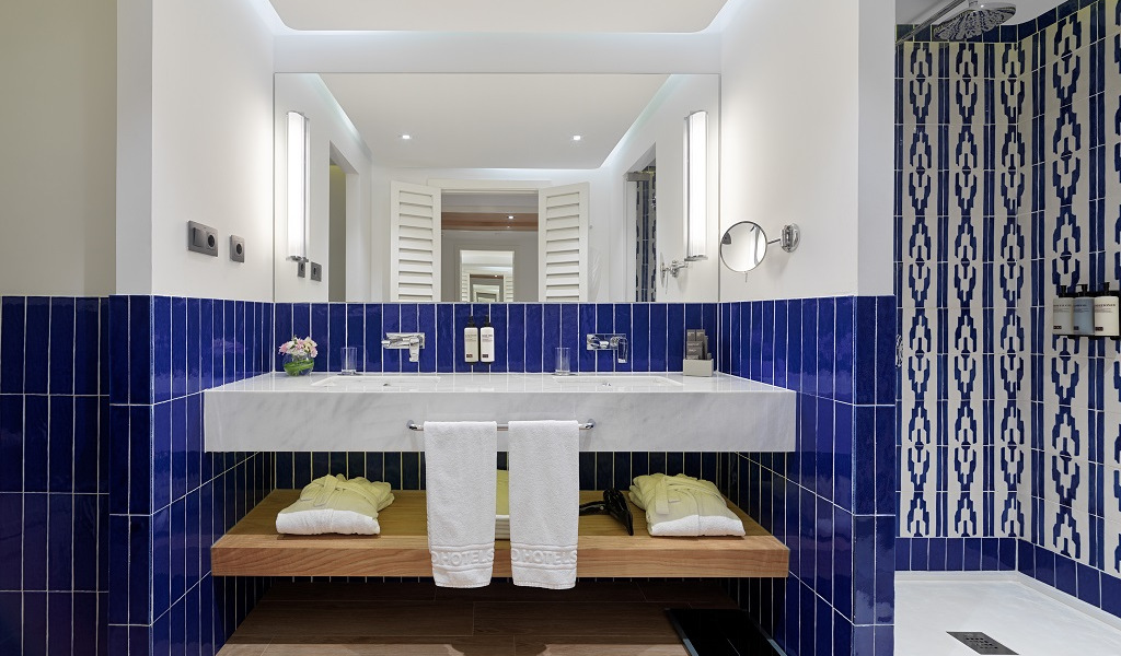 Modern bathroom in Puerto de la Cruz hotel, with blue tiles and double sink.